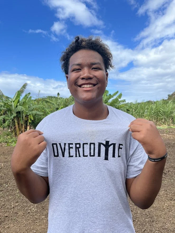 A camper proudly wearing an Overcome shirt in Kauai