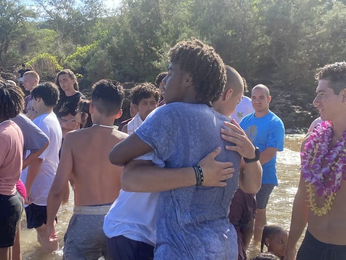Two Overcome campers sharing an embrace outdoors